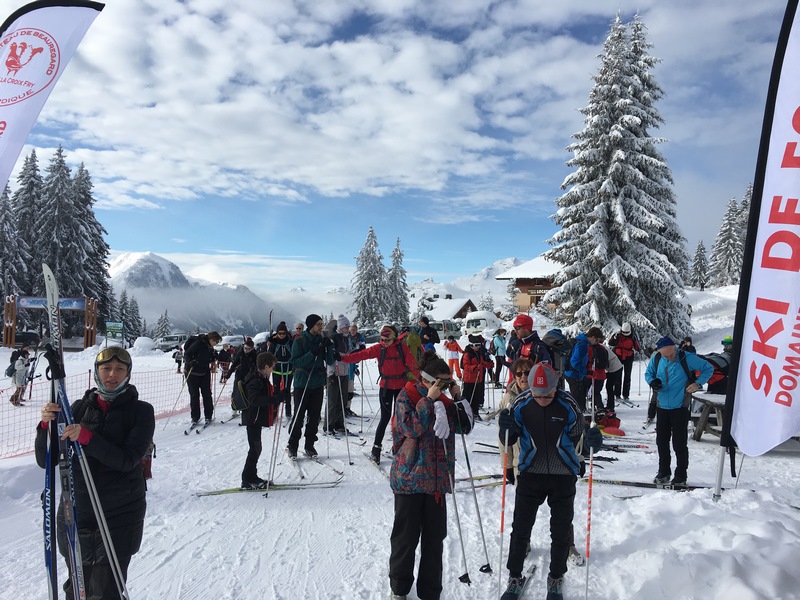 des skieurs nordiques heureux se pressent au départ du tracé de ski de fond.